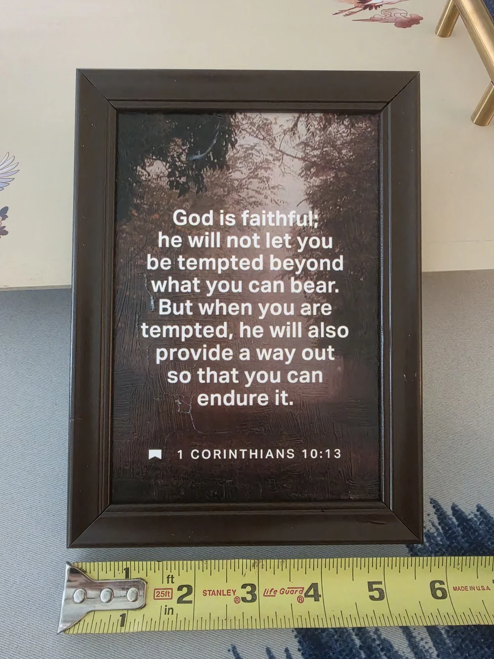 Framed print in the image features the biblical passage 1 Corinthians 10:13